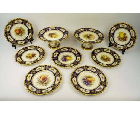 ROYAL WORCESTER PLATES, seven and two comports signed R Sebright, early 20th century decorated with fruit on a cobalt blue an