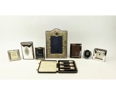A COLLECTION OF SILVERWARE, comprising Rococo embossed photo frame, three smaller photo frames, a mantel clock, a silver cove