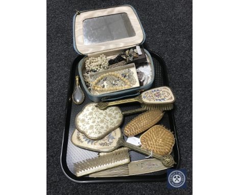 A tray containing box of costume jewellery, gilt and glass teardrop perfume bottle, petit point dressing table set, hand fan