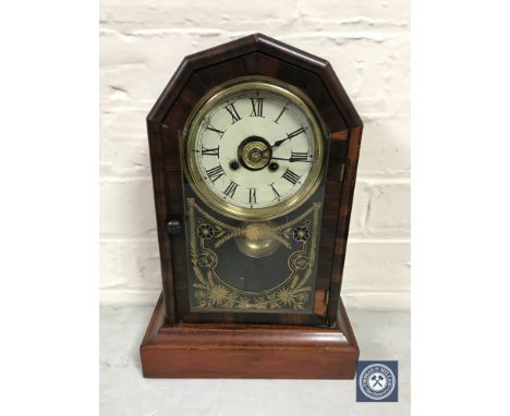 A mahogany and walnut cased walnut mantel clock with pendulum and key