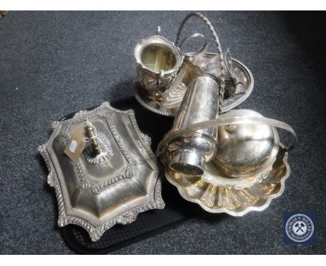 A tray containing antique plated wares including entree dish and cover, swing handle basket, muffin dish, cocktail shaker etc