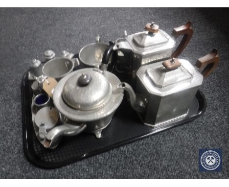 A tray containing early 20th century pewter ware including four-piece craftsmen pewter tea service, three-piece pewter tea se