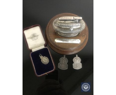 Two sterling silver ARP badges, a Ronson table lighter on wooden stand presented to Major S Anderson MBE and a 1913 National 