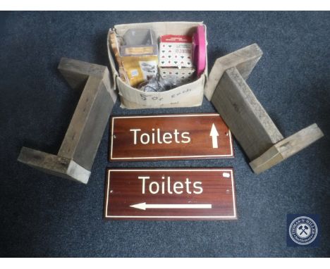 Two wooden toilet signs, two wooden crackets and a box containing metal coat hooks, card shuffler, wooden pieces etc