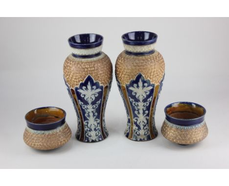 A pair of Royal Doulton Lambeth stoneware baluster vases, decorated in light relief with panels of foliage on blue ground, wi