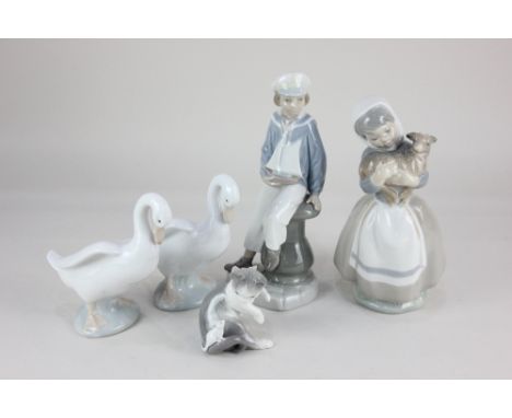 A Lladro porcelain figure of a boy holding a sailing boat, 23cm high, and a Lladro model of a kitten playing with a mouse, 8c