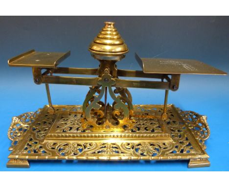 A set of Townsend & Co. brass postage scales, marked to pan with letter rates with stack of wights to centre, the cast base w