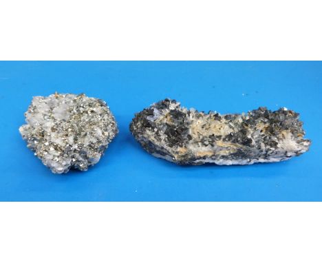 Two geological samples, one formed of dark grey pyrite and some translucent crystals, the other of smaller light grey stone a