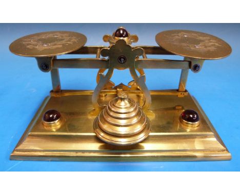 A set of possibly Mordan brass postage scales, set with three red cabochons the pans both engraved with leaves and quatrefoil