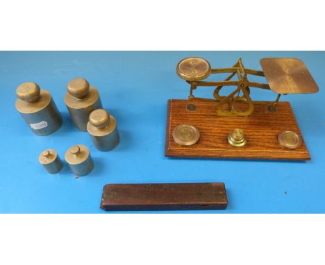 A cased set of guinea scales, a set of postage scales and various cylindrical weights 