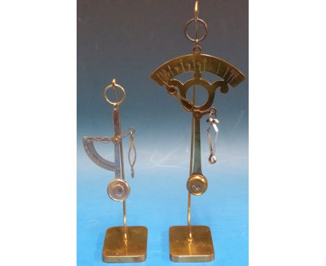 Two sets of pendulum type letter scales, one marked Jos Illfelder, both on brass display stands 