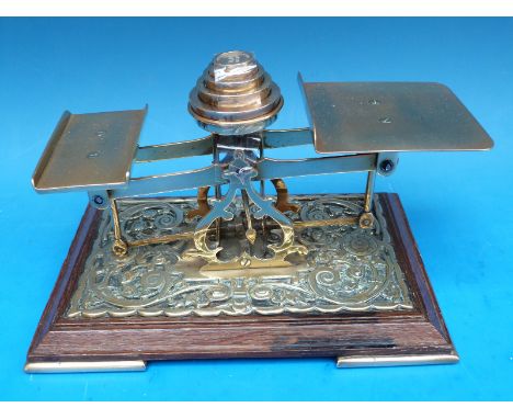A set of brass and oak postage scales with weights to centre 