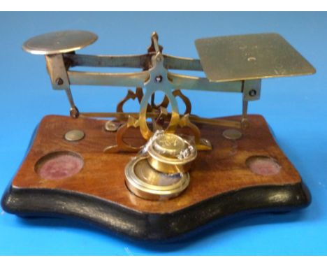 A set of brass postage scales with rates to pan, the walnut base fitted weights 