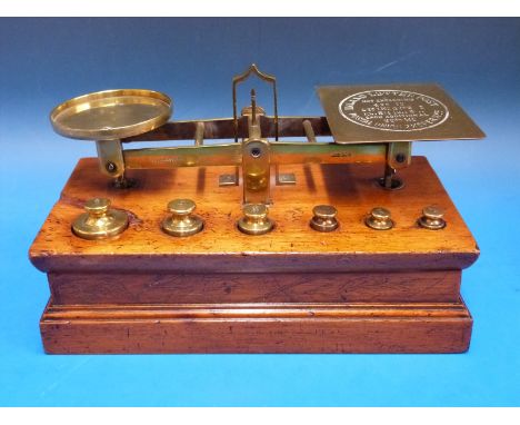 A set of S. Mordan & Co. postage scales having postage rates to pan, the mahogany base fitted with cylindrical weights