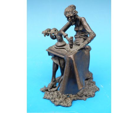 A bronze of a lady at a sewing machine monogrammed JE 76 to base (height 11cm)