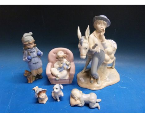 A Nao figure of a girl nursing a doll together with a Spanish model of a boy with donkey and other similar ceramics etc 