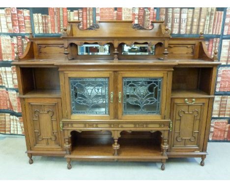 A late 19thC break front sideboard with over shelf and bevelled mirrors to top, glazed cupboard and shelf below to centre fla