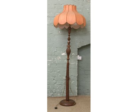 An extensively carved oriental style mahogany standard lamp and shade.
