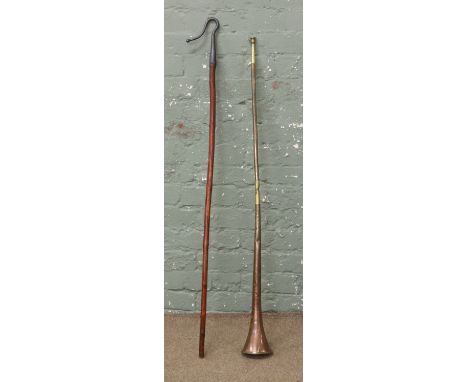 A brass and copper hunting horn and a shepherds crook.
