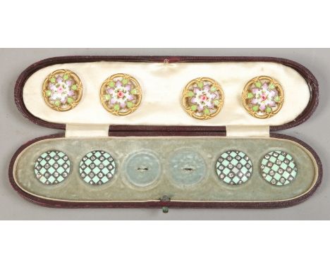A case containing two part sets of enamel buttons, one set gilt metal, the others set with white paste stones.