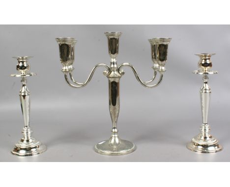 A garniture of silver plated candlesticks including a five branch centre candelabra.
