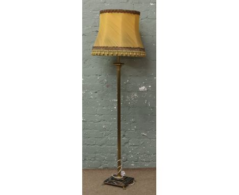 A brass column standard lamp and shade on decorative marble base.