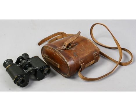 A pair of vintage brass military issue binoculars in leather case, broad arrow marks to both.