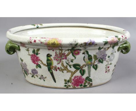 A decorative ceramic planter decorated with colourful flowers and birds.