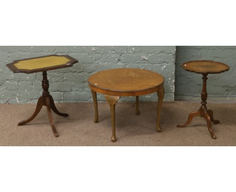 A leather tilt top wine tripod table along with another and a round occasional table.