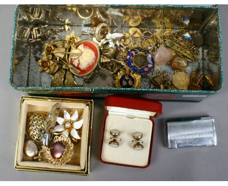 A tin of costume jewellery and collectables including pheasants foot brooch, gents studs, penguin gas lighter and quartz piec