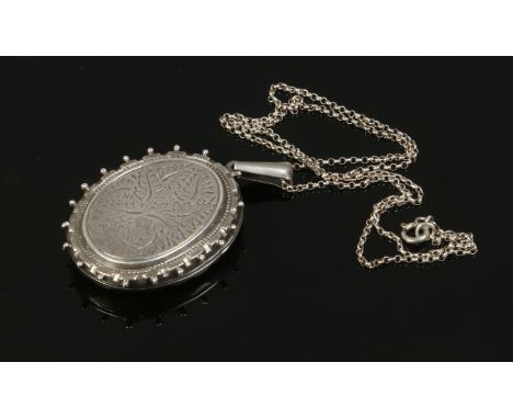 An engraved silver locket on chain.