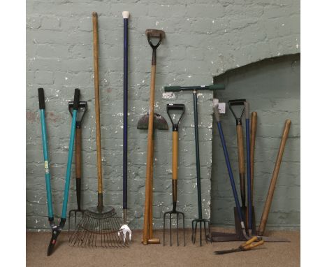 A collection of garden tools to include a rake, hedge cutters and spade etc.