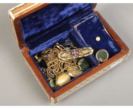 An inlaid musical jewellery box and collection of costume jewellery including nephrite leaf pendant, amethyst bar brooch and 