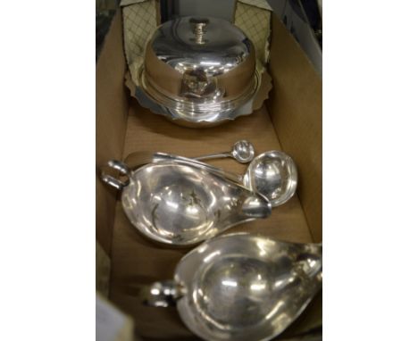 A plated muffin dish, two sauce boats, sauce ladle and a mustard spoon.