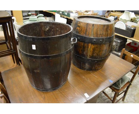 A large barrel shaped planter or stick stand together with another large wrought bound oak barrel shaped stand.