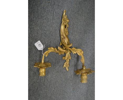 An ormolu twin branch wall light, decorative trays and a mirror.