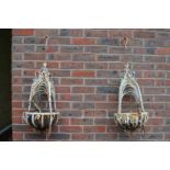 A pair of metal hanging baskets.