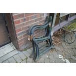 A pair of heavy cast iron bench ends with matching centre support.