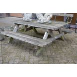 A pine picnic table with bench seats.