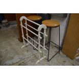 A painted towel rail and a pair of stools.