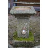 A reconstituted stone bird bath.