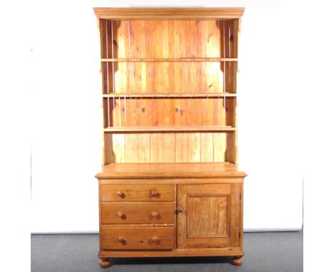 Stripped pine Lincolnshire dresser base, with three drawers and panelled door, 126cm; with a matched three shelf rack, 215cm.