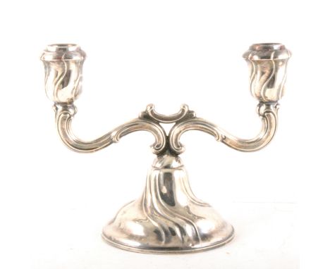 German silver two light candelabra, 835 standard, twin scrolled branches, a wrythen moulded base, weighted, 17cm.