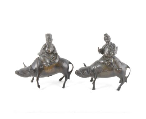 A pair of Asian bronze censers, each designed as a man riding a water buffalo, height 15cm.