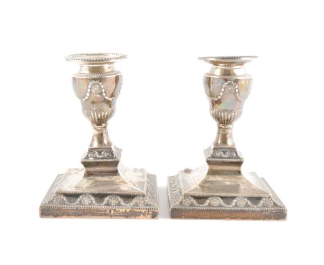 A pair of Victorian silver dwarf candlesticks, J. K. B., Sheffield, 1889, of neo classical design, square bases, damaged, 14c