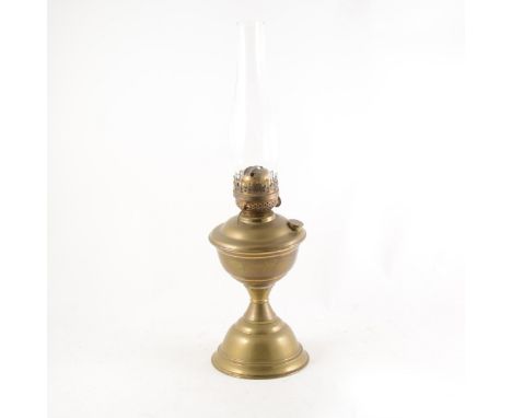 A brass oil lamp, marked British Made and with a V stamped on the base, height to burner 33cm, including chimney 54cm.