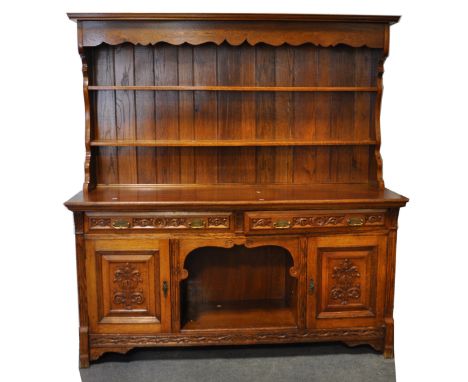 Late Victorian carved oak sideboard, fitted with two frieze drawers, two panelled doors flanking central recess, length 183cm