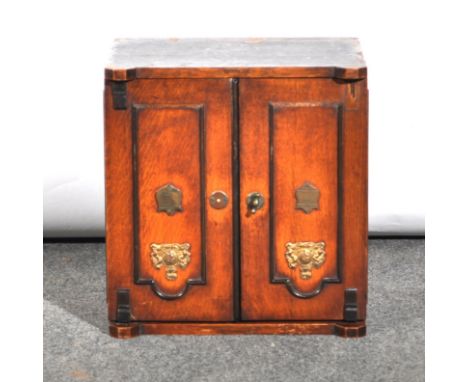 Victorian oak smoker's cabinet, designed as a safe, two doors with applied mounts, enclosing a fitted interior with drawers, 