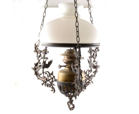 A cast metal centre light fitting, supporting a brass reservoir and opaque shade, 54cm drop.