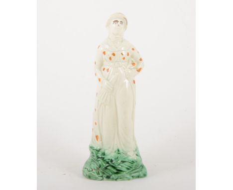 A creamware figure of a lady, late 18th century, in a polka dot gown coloured ochre in overglaze enamel, holding an umbrella,